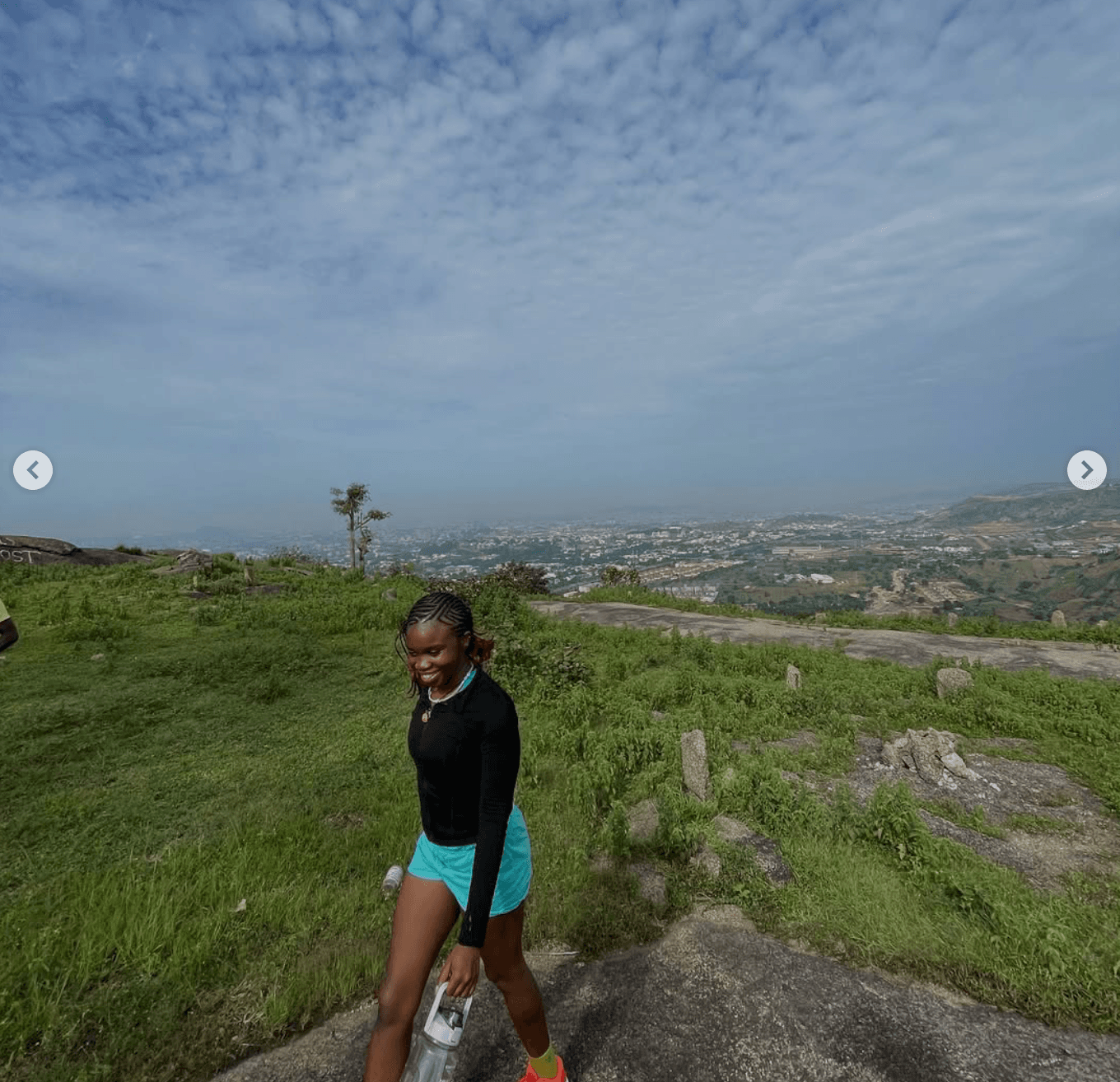 Young adults gathered around a campfire in warm evening light