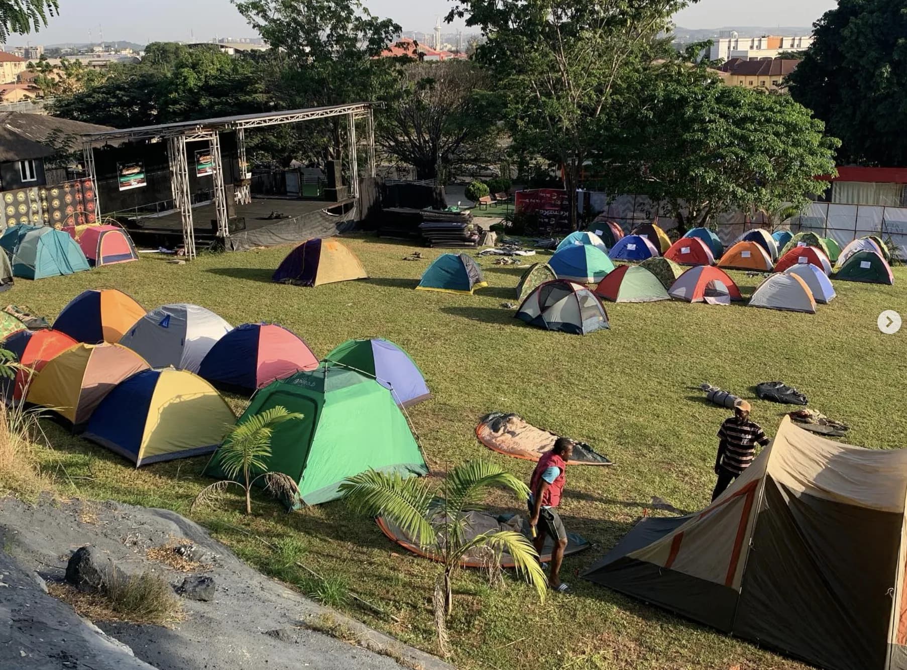 Colorful tents spread across a green hillside at a Camping Nigeria event